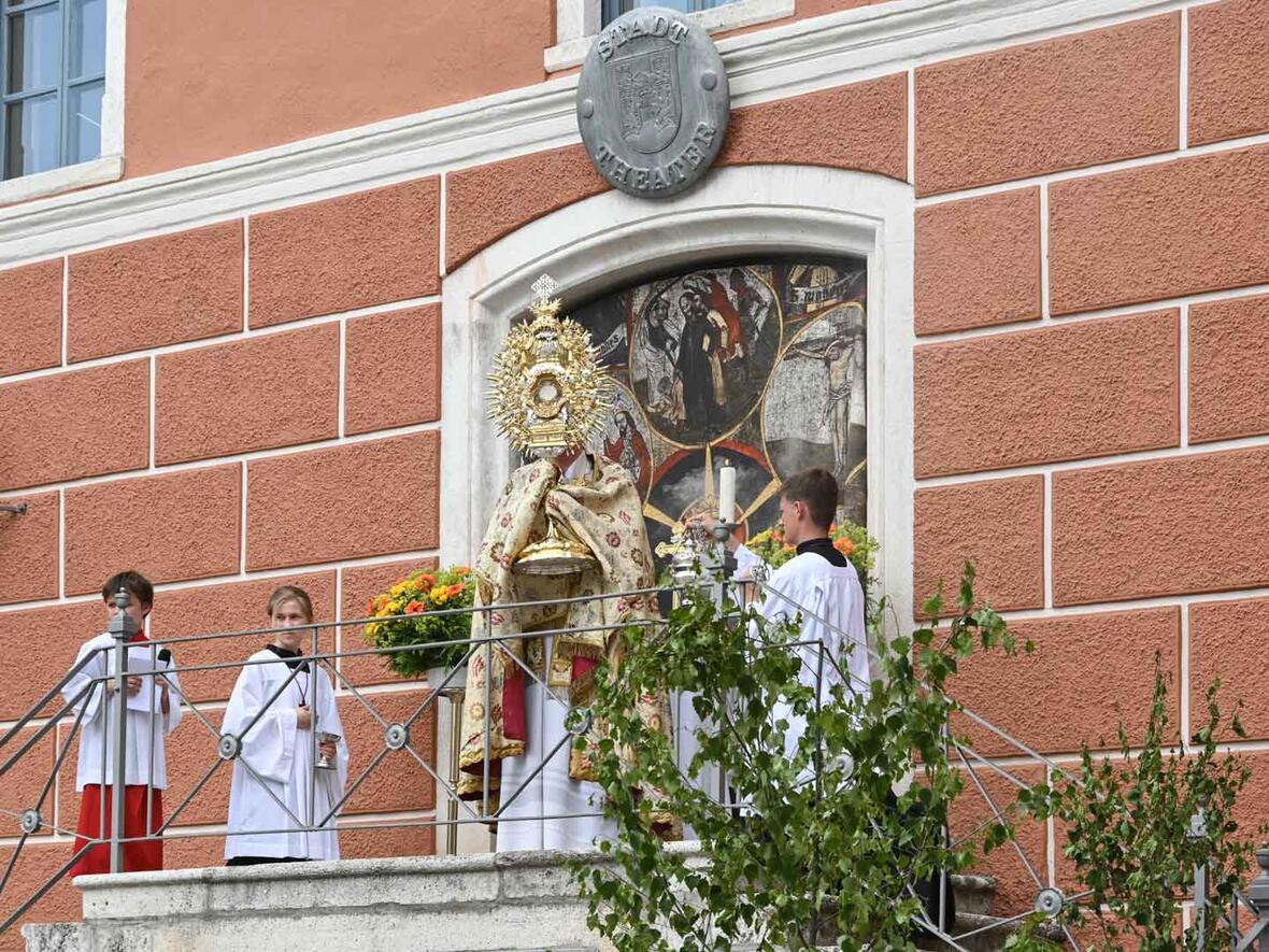 Pfarrer Herbert Kohler segnet die Gläubigen mit der großen Monstranz am Altar beim Stadttheater