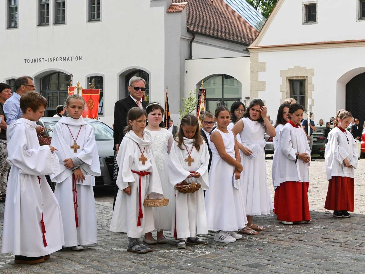 Kommunionkinder mit Alben und Kommunionkleidern und auch schon als Ministrantinnen