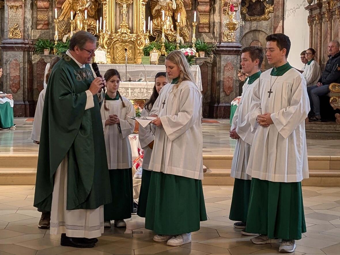 Traditionell obliegt es den Oberministranten, den Neuen ihr Ministrantenkreuz anzulegen.
