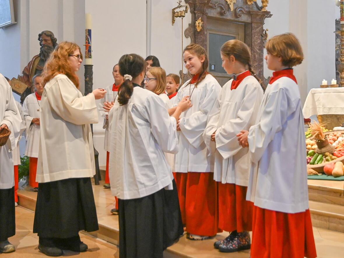 Ministranten Einführung in St. Peter am Erntedankfest Die Oberministrantinnen Luisa und Christine überreichen die Ministrantenkreuze,
