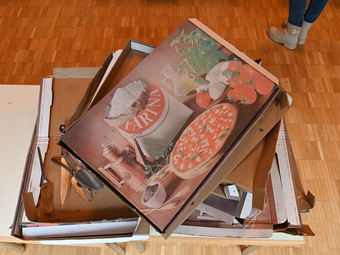 Von 7 Quadratmetern Pizza sind 14 leere und jetzt alte Pizzaschachteln übrig. 