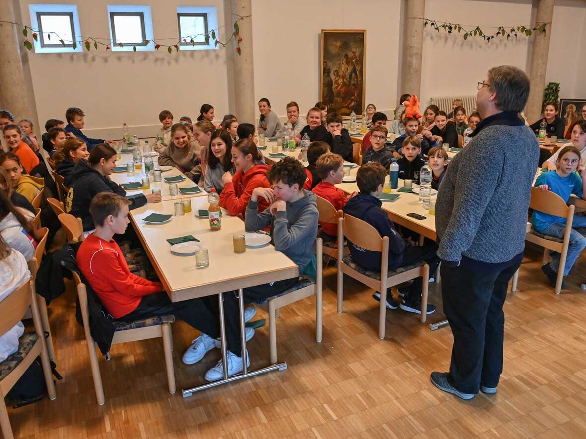Wir nennen es Teil 2 des Gruppenbildes. Pfarrer Dominic Leutgäb stimmt das Tischlied an.
