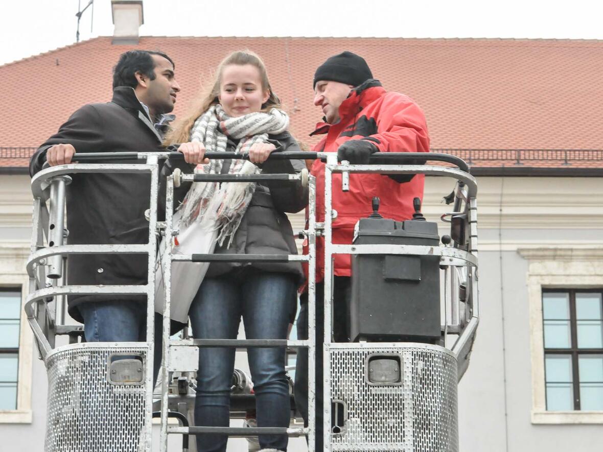 Firmvorbereitung 2016 zum Thema Ehrenamt: Monika mit Pater Shenoy und einem Mann der Freiwilligen Feuerwehr Neuburg hoch über dem Karlsplatz