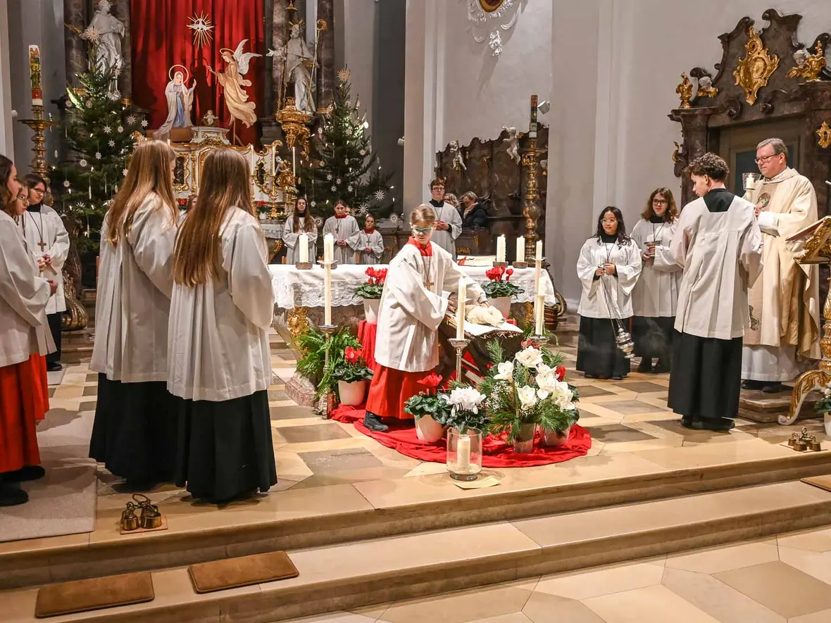 Die Gemeinde versammelt sich um das Kind in der Krippe