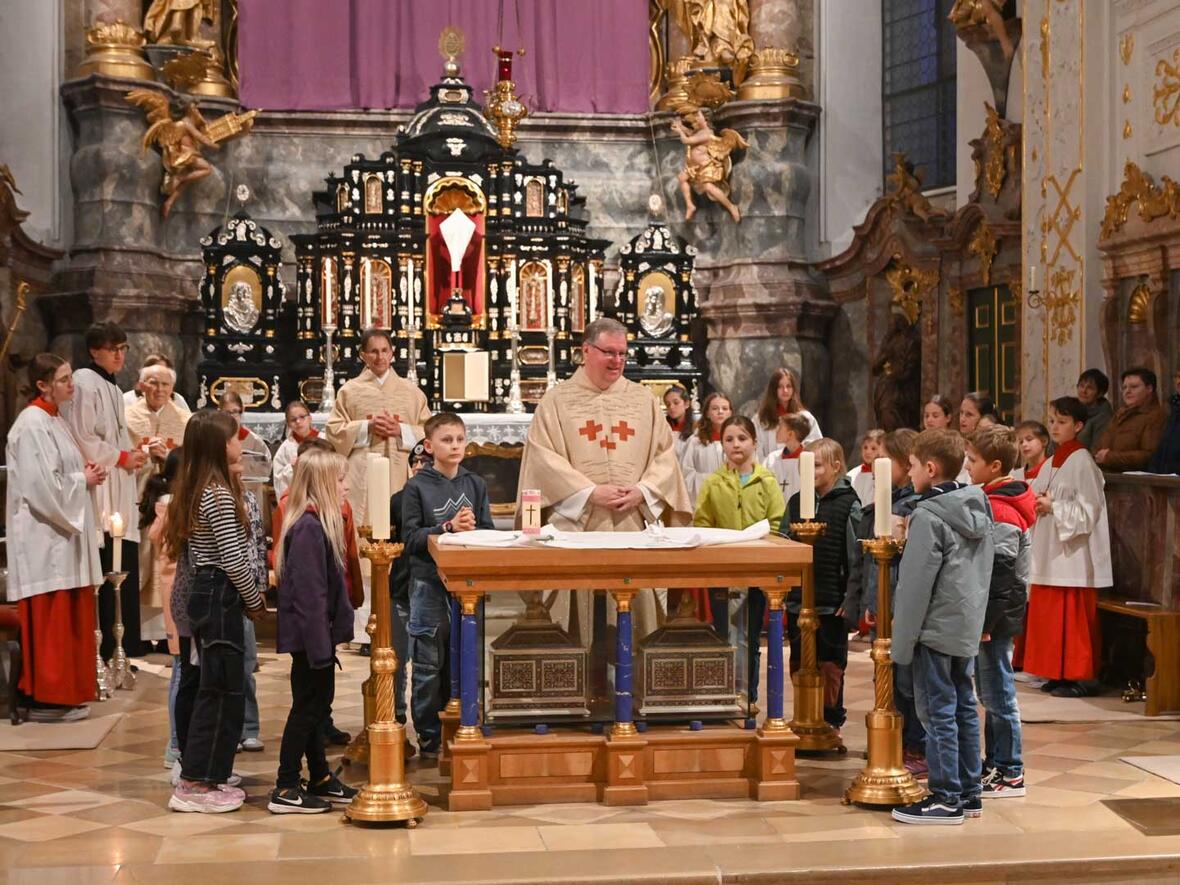 Kommunionkinder entblößen mit Pfarrer Kohler den Altar. Der Tabernakel ist schon leer.