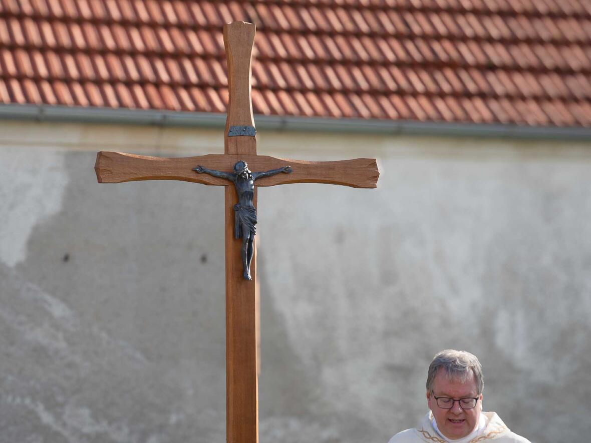 Das fein gestaltete Holzkreuz hinter der Kirche