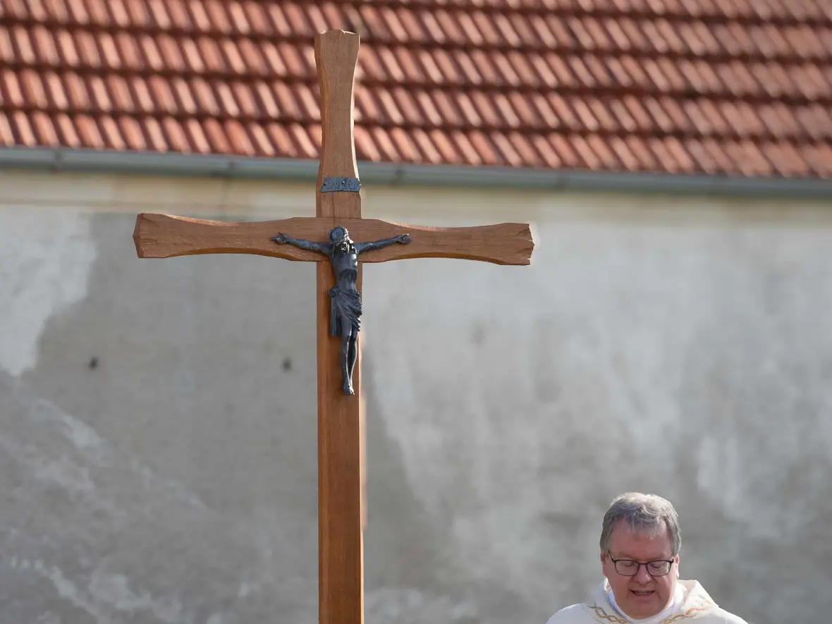 Das fein gestaltete Holzkreuz hinter der Kirche