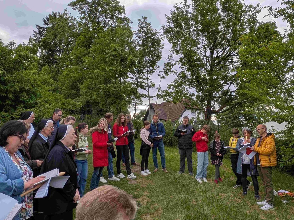 Schüler, Eltern, Lehrer, Schwestern und Gemeindemitglieder beim gemeinsamen Singen und Beten
