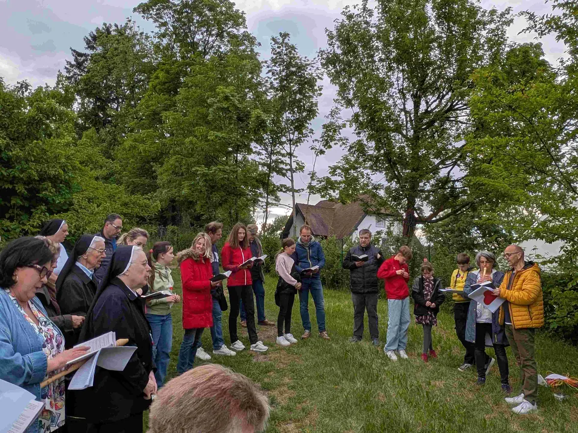 Schüler, Eltern, Lehrer, Schwestern und Gemeindemitglieder beim gemeinsamen Singen und Beten
