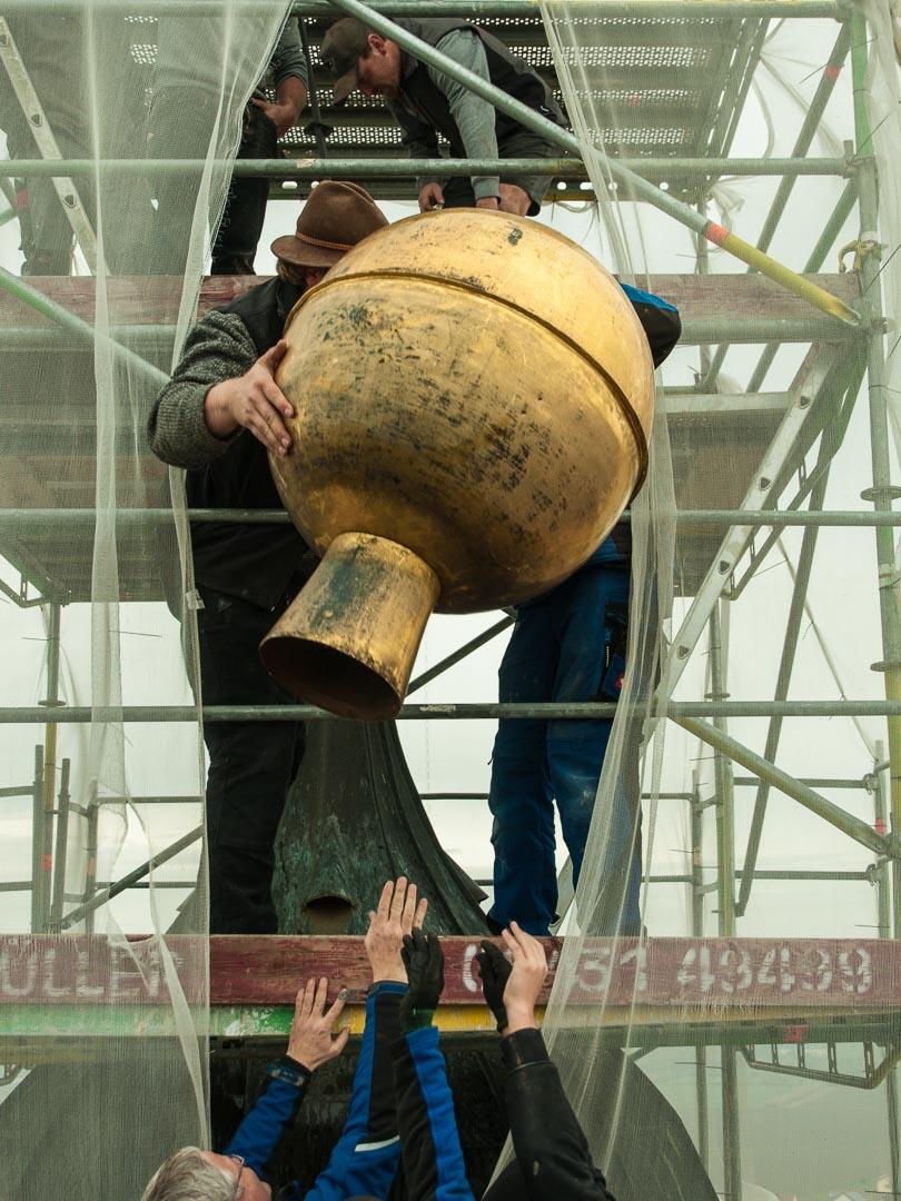 Zimmerleute und Spengler hieven die Kugel auf die oberste Plattform des Gerüstes. Wieder Teamwork.
