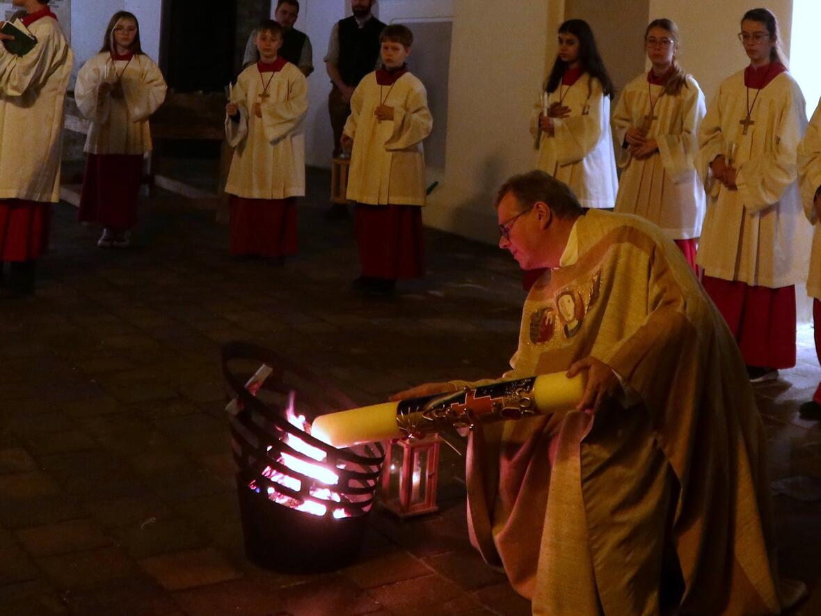 Pfarrer Kohler entzündet die Osterkerze am Osterfeuer.