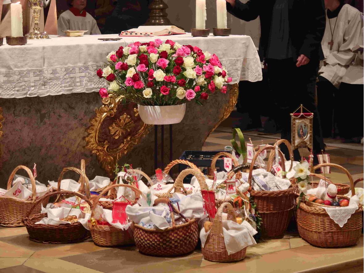 Reichlich Speisekörbe, die auf die Weihe warten, vor dem festlich geschmückten Altar.